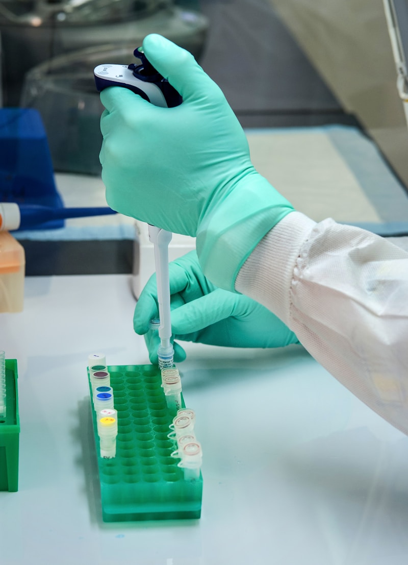 Laboratory technician using a micropipette to process blood specimens in color-coded tubes