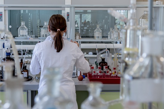 Laboratory technician working at a clinical chemistry bench with reagents and analyzers