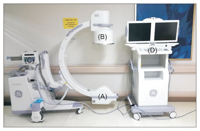 C-arm fluoroscopy system in interventional radiology suite showing flat-panel detector and X-ray tube configuration